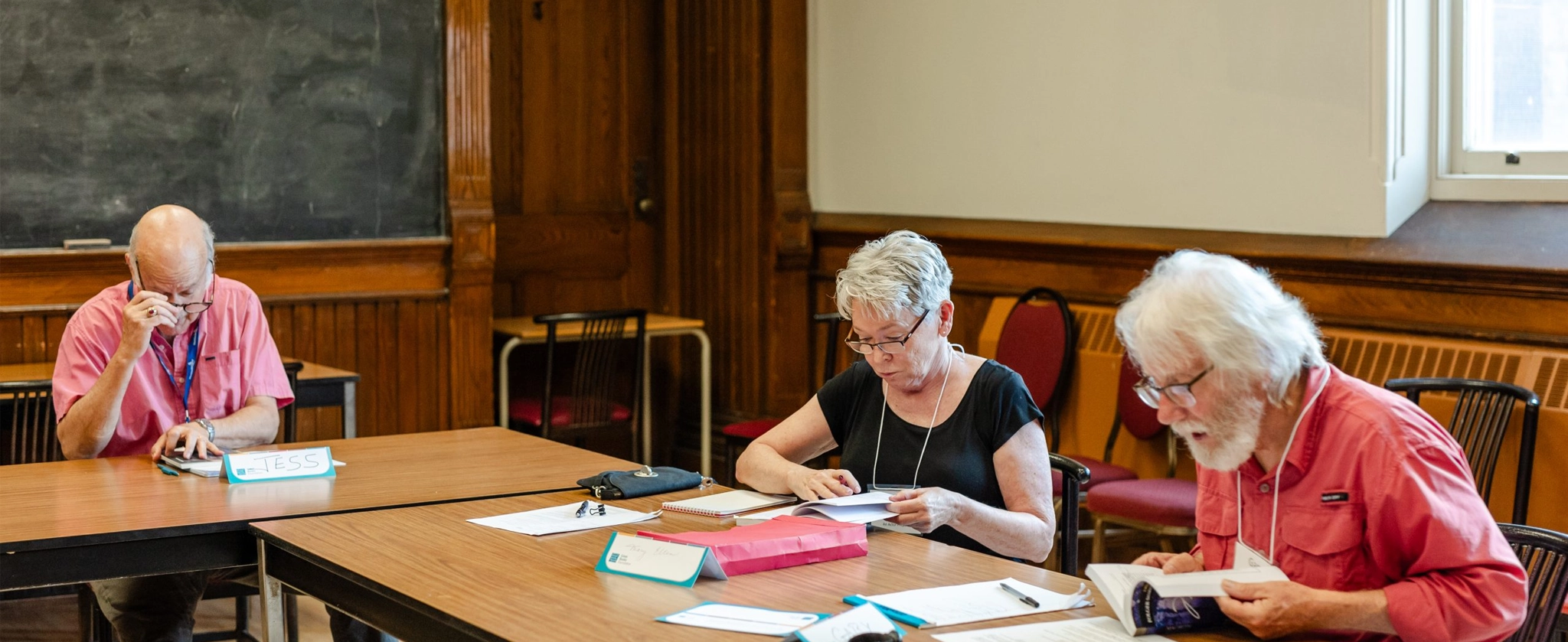 A group of people in a classroom reading a text